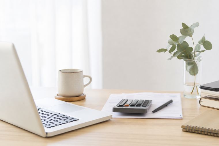 Scrivania con due monitor accesi, tastiera e una tazza di caffè accanto alla postazione di lavoro.